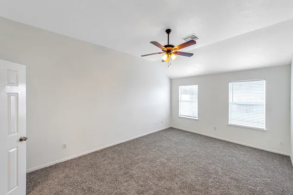 a view of a room with a ceiling fan and wooden floor