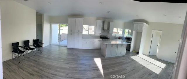 a large hall with white cabinets and wooden floor