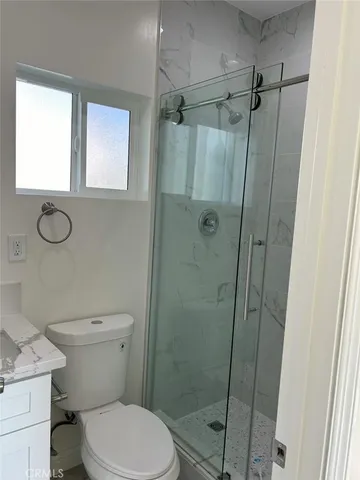 a bathroom with a toilet and a shower