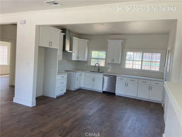 a large kitchen with a wooden floor and a sink