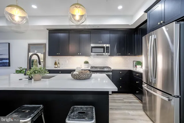 a kitchen with a refrigerator and a stove top oven