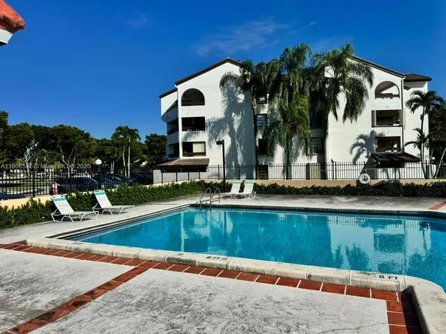 a view of swimming pool with outdoor seating and house in the background
