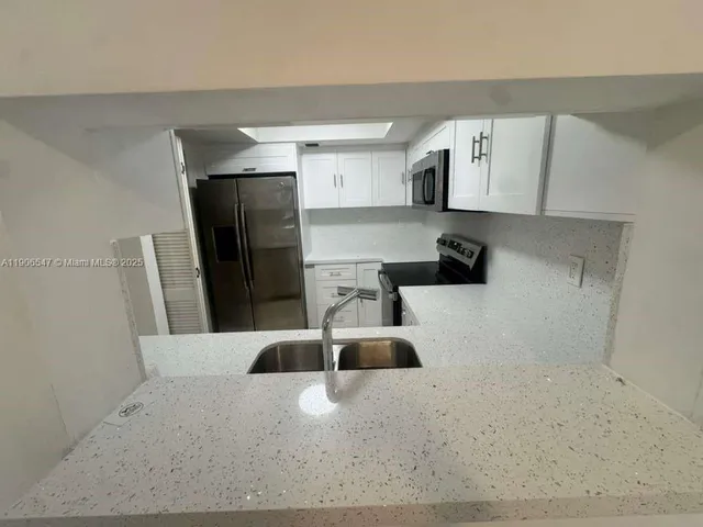 a kitchen with a sink and refrigerator