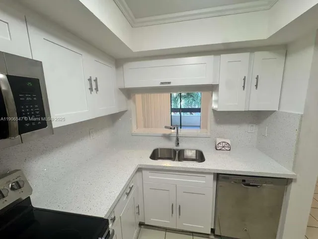 a kitchen with a sink cabinets and window