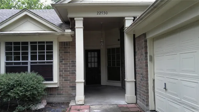 a view of a house with a yard and potted plants