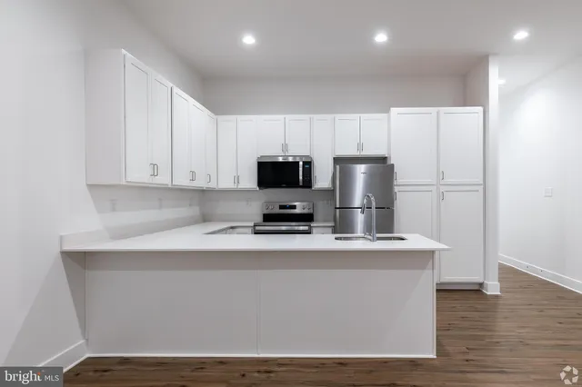 a kitchen with stainless steel appliances a microwave a sink and a refrigerator