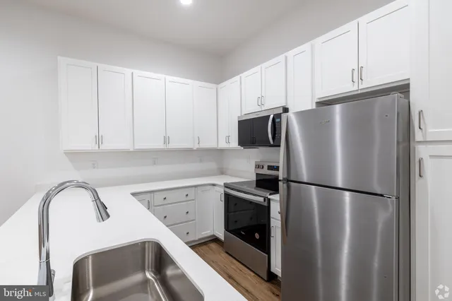 a kitchen with a refrigerator sink and cabinets