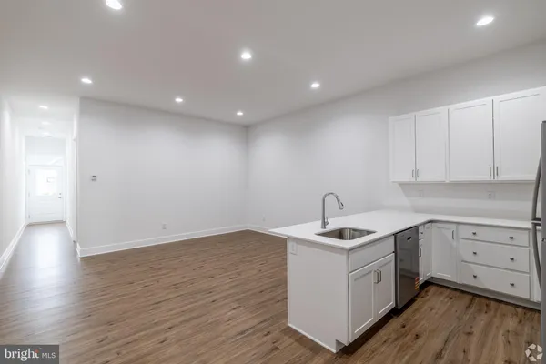 a kitchen with a sink cabinets and wooden floor