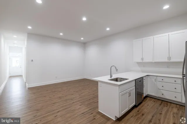 a kitchen with a sink cabinets and wooden floor