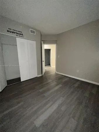 an empty room with wooden floor and closet