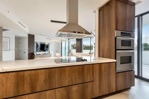 a kitchen with stainless steel appliances granite countertop a sink a stove and a refrigerator