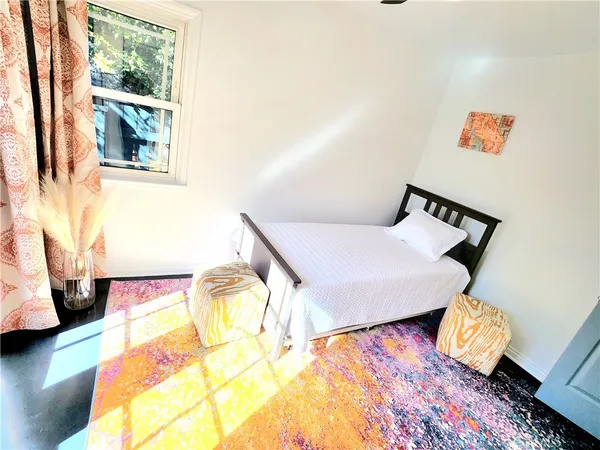 a large bed sitting in a bedroom next to a window