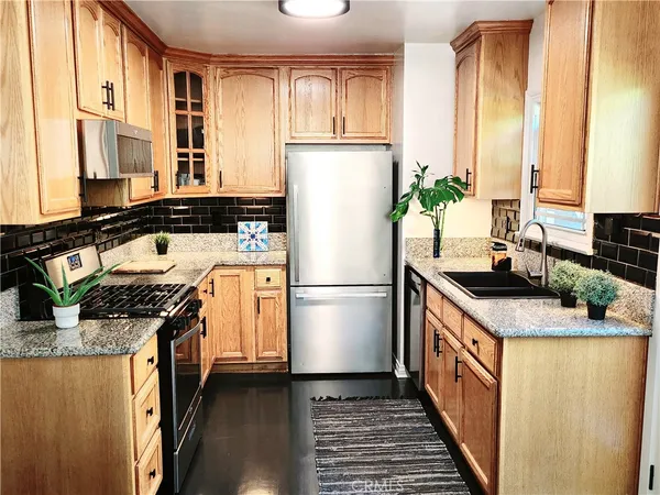 a kitchen with stainless steel appliances a refrigerator sink and cabinets