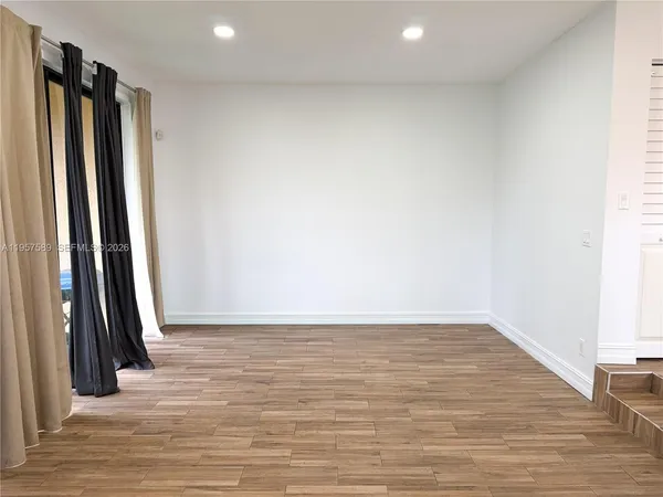 a view of a room with wooden floor and a window