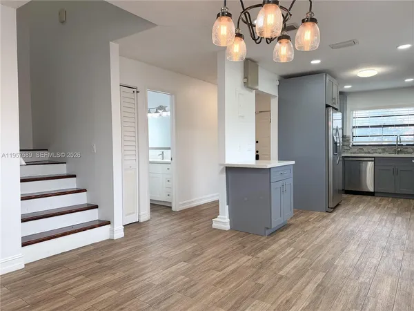 a view of a kitchen with a sink and dishwasher a kitchen view with wooden floor