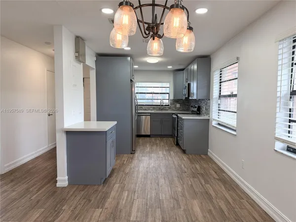 a kitchen with stainless steel appliances granite countertop wooden floors and sink
