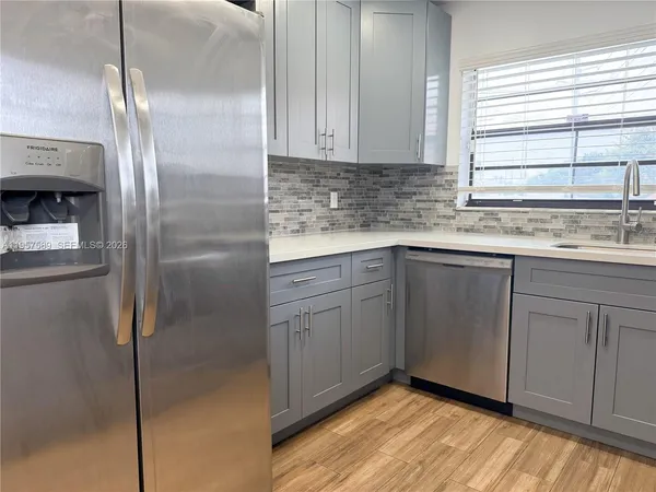 a kitchen with a sink cabinets and wooden floor