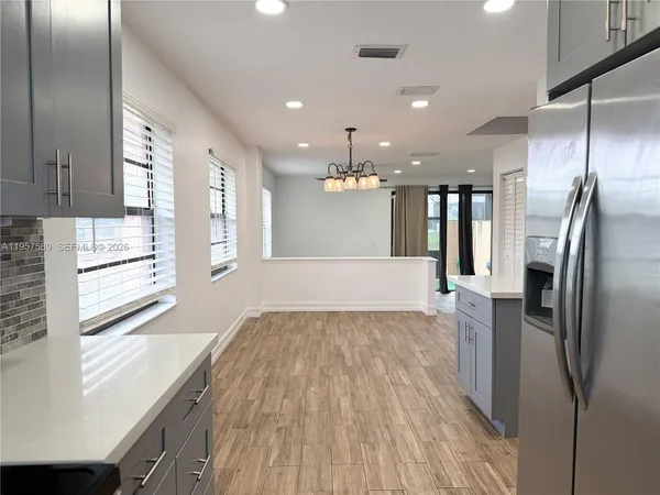 a kitchen with stainless steel appliances granite countertop a refrigerator and a sink