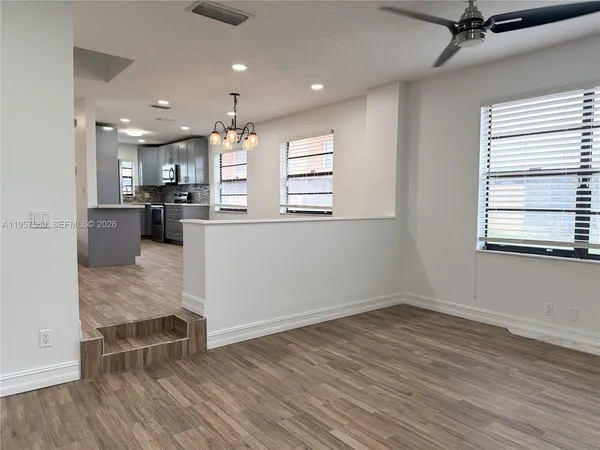 a kitchen with stainless steel appliances kitchen island hardwood floor sink stove and wooden cabinets