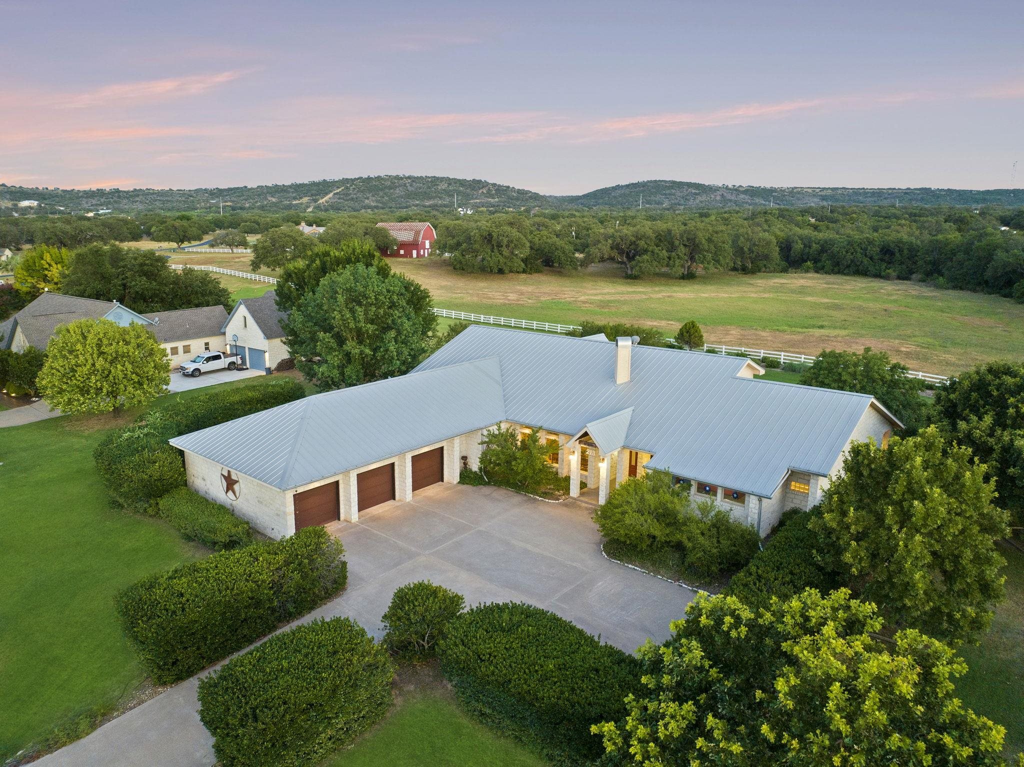 an aerial view of a house with green landscape and view of residential houses with outdoor space and trees