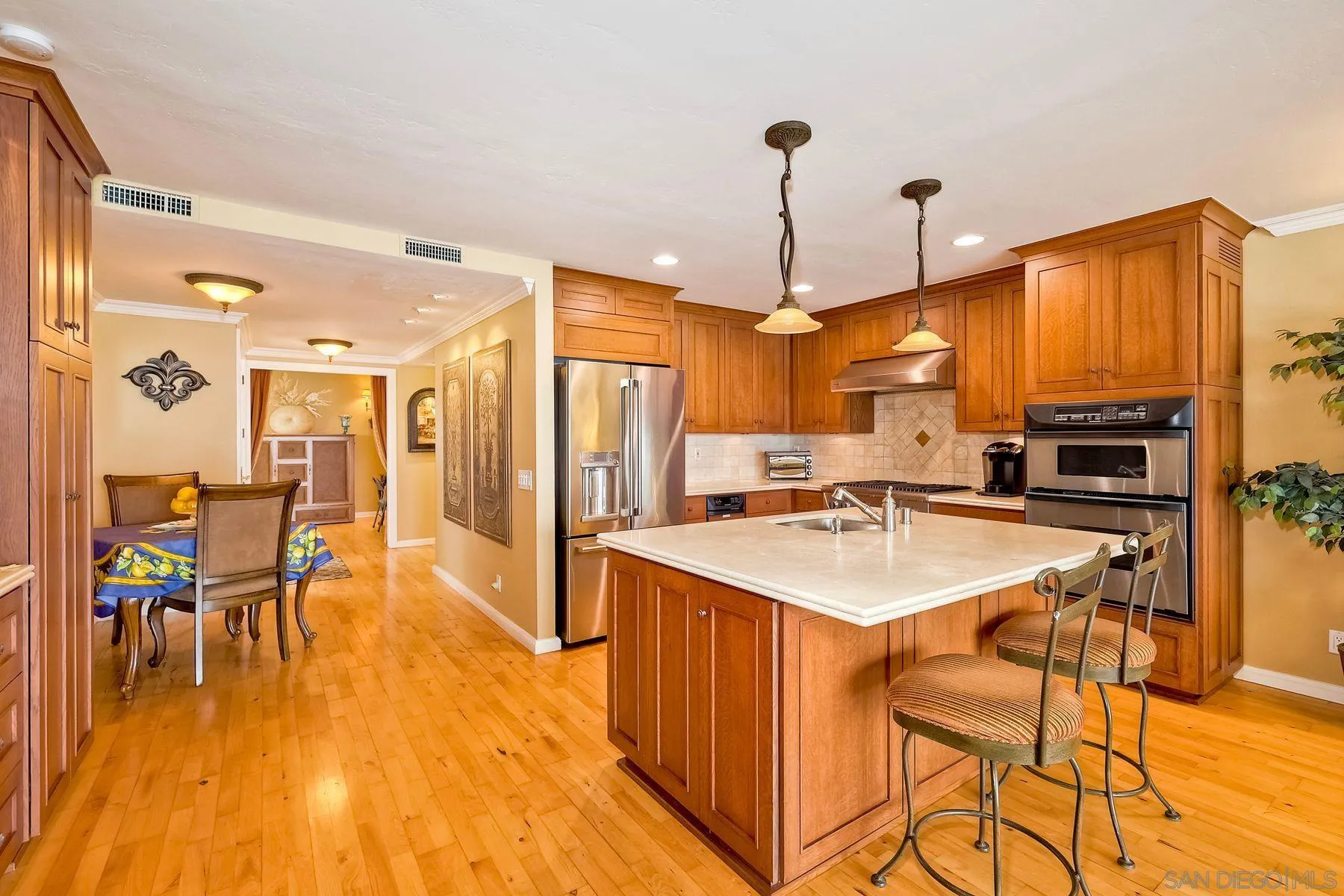 720 4th Street, Unit 1 Encinitas, CA 92024 - Photo 12 of 29 a kitchen with stainless steel appliances a stove a sink a refrigerator a dining table and chairs with wooden floor