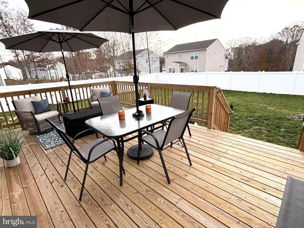 a view of deck with furniture and umbrella