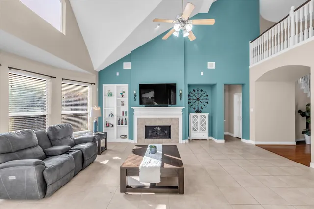 a living room with furniture a flat screen tv and a fireplace
