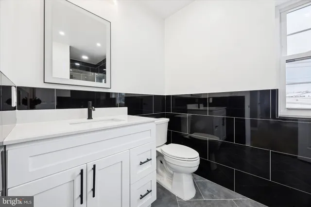 a bathroom with a sink a toilet a vanity and mirror