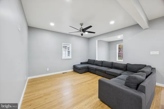 a living room with furniture and a ceiling fan