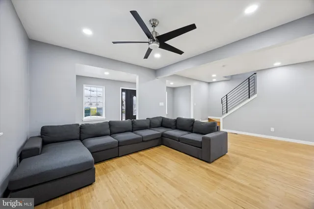 a living room with furniture and a ceiling fan