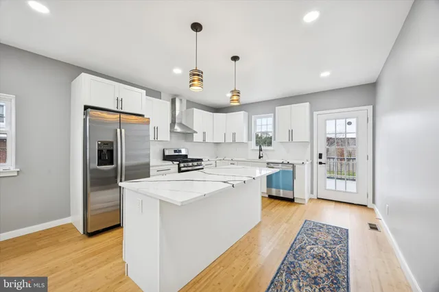 a large kitchen with kitchen island a sink stainless steel appliances and cabinets