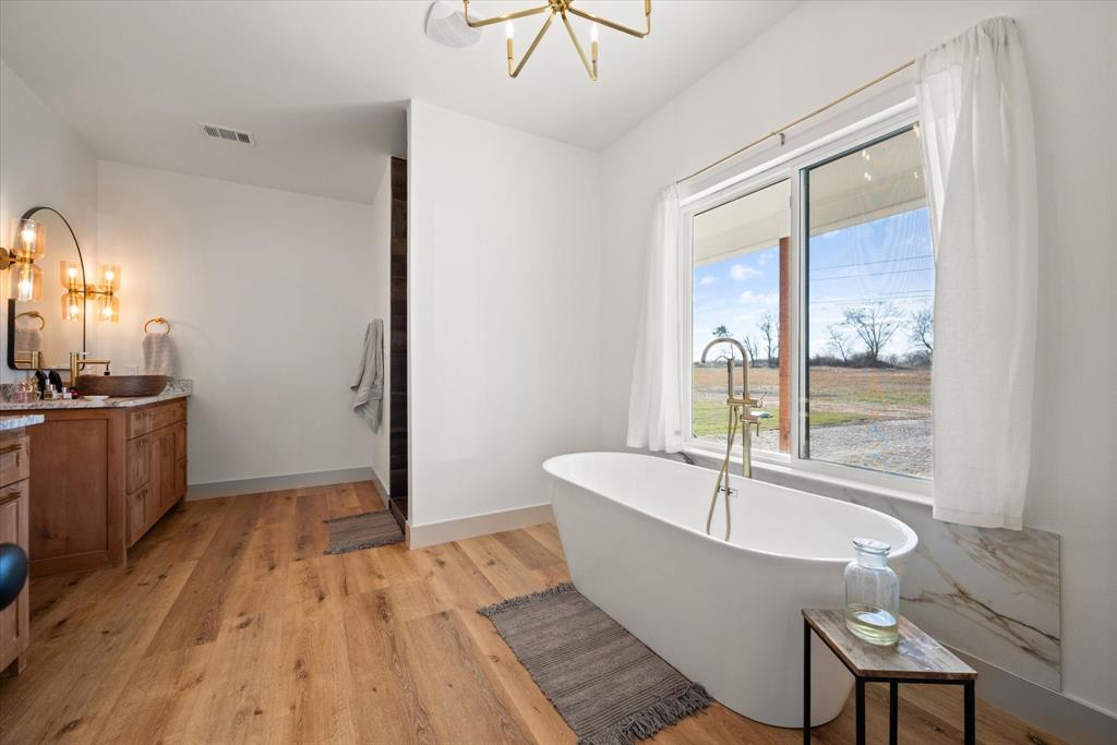 618 Minnis Road Collinsville, TX 76233 - Photo 25 of 37 a large white tub sitting in a bathroom next to a window