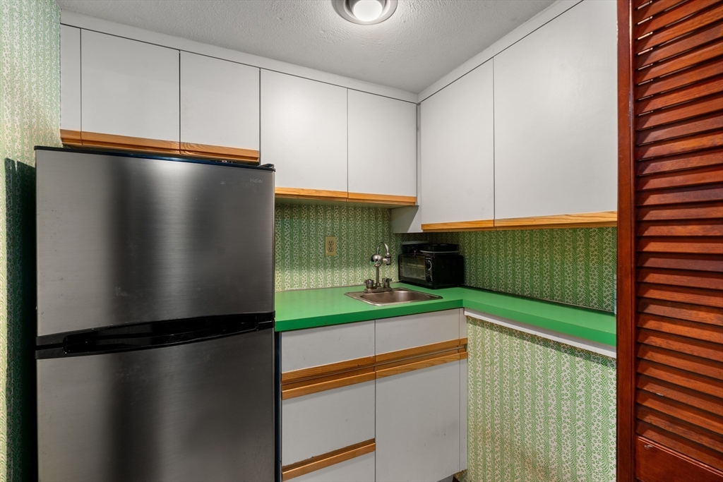 7 Van Beal Road Randolph, MA 02368 - Photo 26 of 35 a kitchen with a refrigerator and a car parked