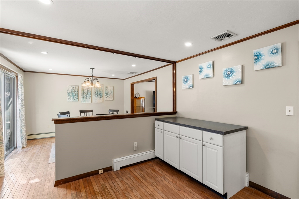 7 Van Beal Road Randolph, MA 02368 - Photo 8 of 35 a kitchen with granite countertop white cabinets and wooden floor