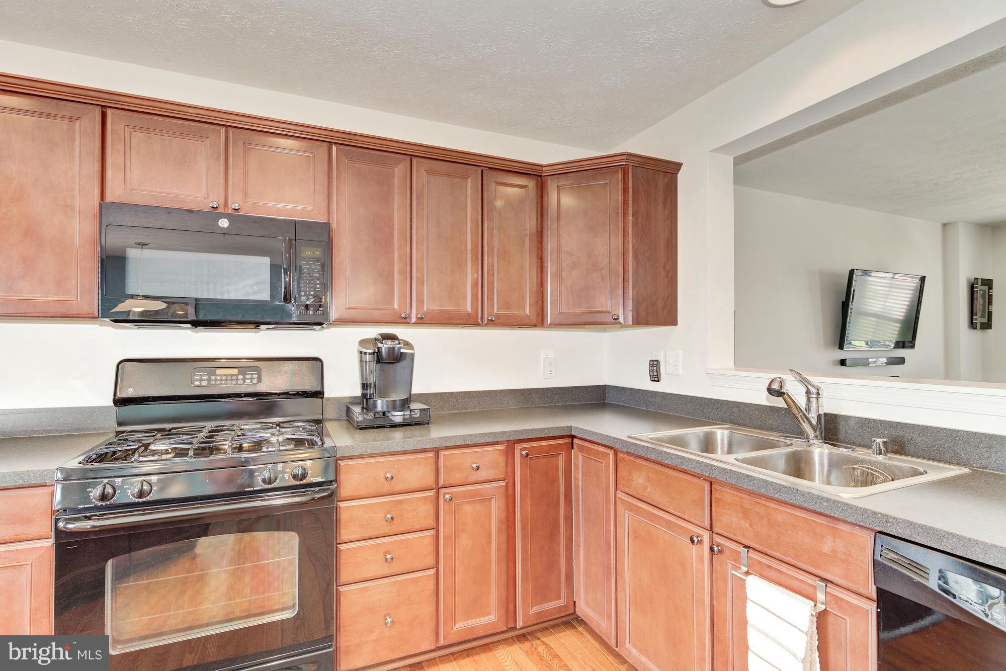 9851 Decatur Road Baltimore, MD 21220 - Photo 11 of 24 a kitchen with stainless steel appliances granite countertop a sink stove and microwave