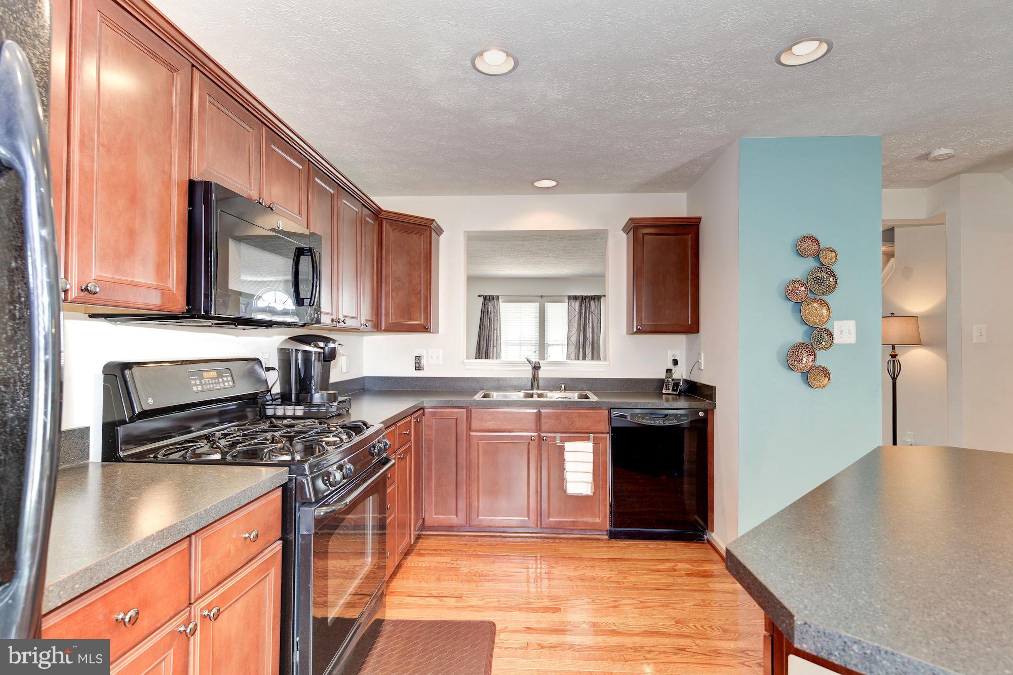 9851 Decatur Road Baltimore, MD 21220 - Photo 10 of 24 a kitchen with stainless steel appliances granite countertop a stove a sink dishwasher and a refrigerator