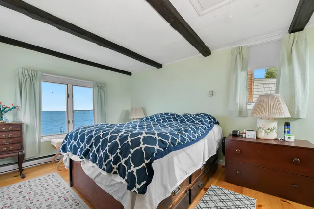 a bedroom with a bed chair and dresser