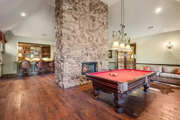 a room with pool table and wooden floor