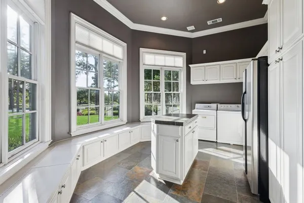 a kitchen with granite countertop a stove and white cabinets