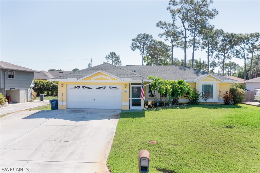 18253 Maple Road Fort Myers, FL 33967 - Photo 1 of 29 a front view of a house with a yard and garage