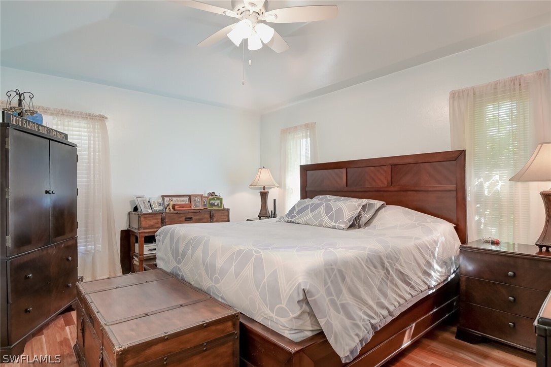 18253 Maple Road Fort Myers, FL 33967 - Photo 13 of 29 a bedroom with a bed and a chandelier