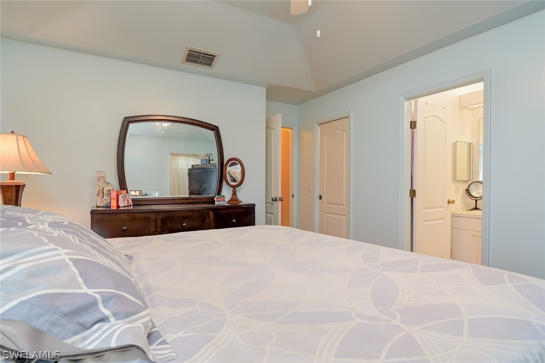 18253 Maple Road Fort Myers, FL 33967 - Photo 14 of 29 a bedroom with a large bed and a large mirror