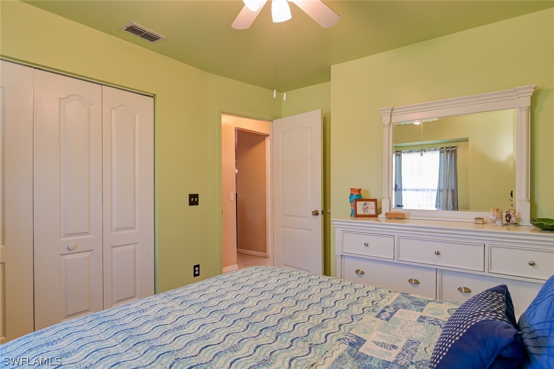 18253 Maple Road Fort Myers, FL 33967 - Photo 18 of 29 a bedroom with a bed and a chandelier