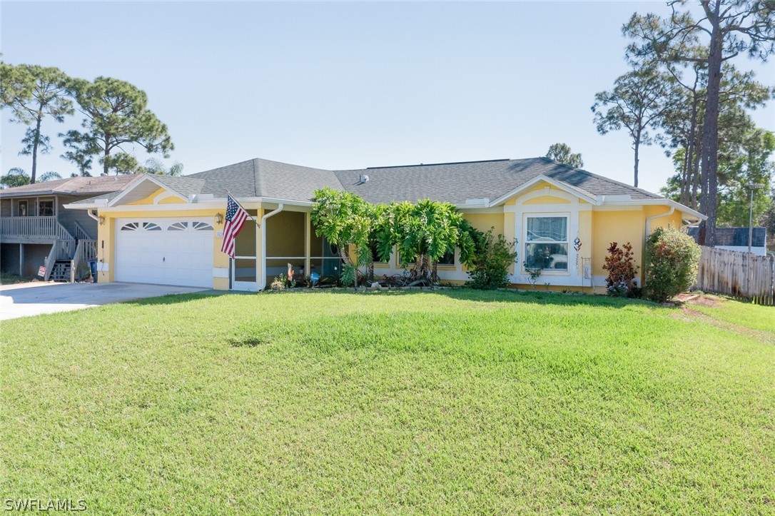 18253 Maple Road Fort Myers, FL 33967 - Photo 26 of 29 a front view of a house with a yard and garage