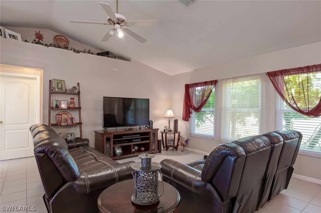 18253 Maple Road Fort Myers, FL 33967 - Photo 4 of 29 a living room with furniture a flat screen tv and a large window