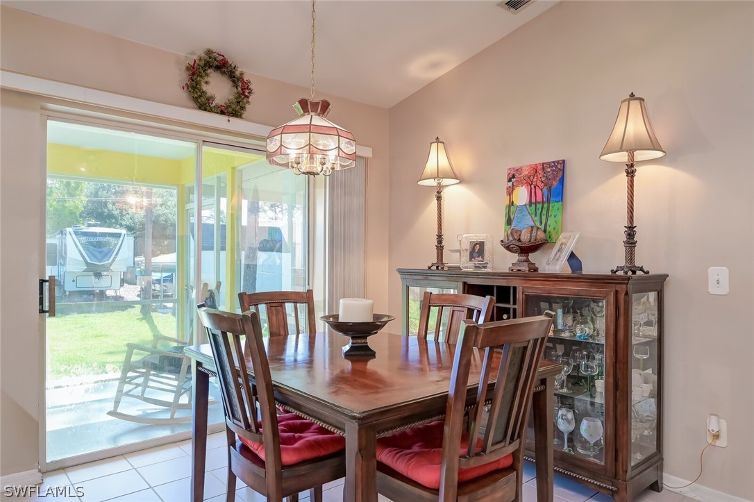 18253 Maple Road Fort Myers, FL 33967 - Photo 8 of 29 a view of a dining room with furniture a chandelier and large windows