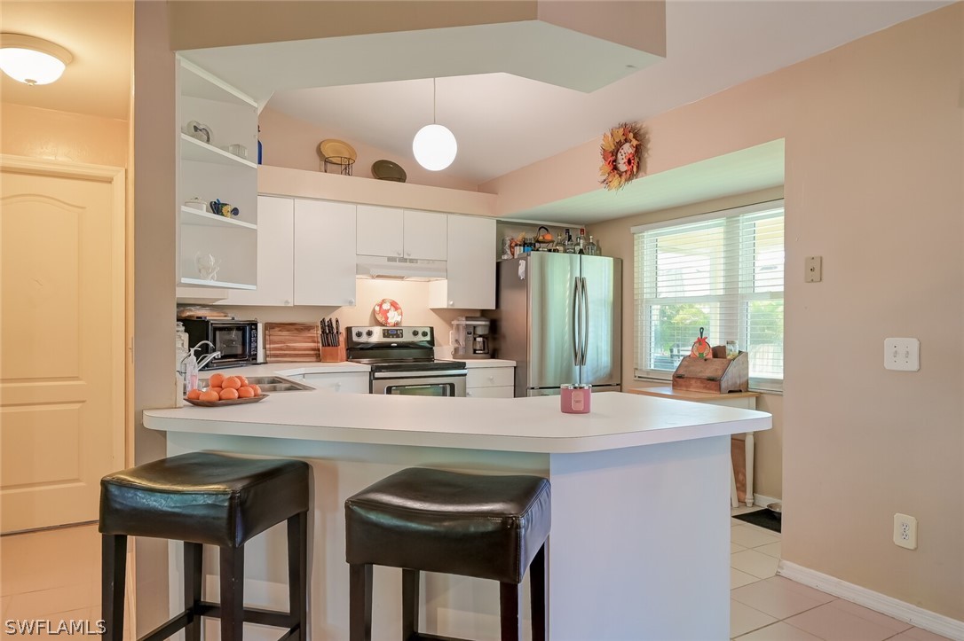 18253 Maple Road Fort Myers, FL 33967 - Photo 9 of 29 a kitchen with a sink a stove and chairs