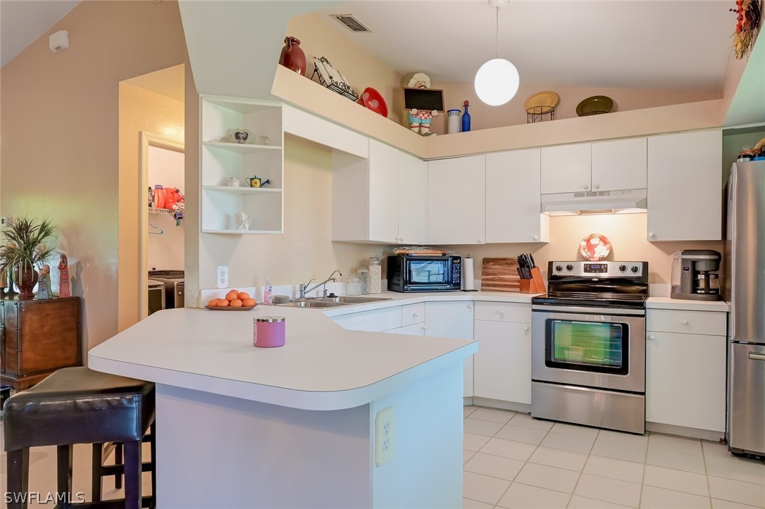 18253 Maple Road Fort Myers, FL 33967 - Photo 10 of 29 a kitchen with a sink a stove and chairs