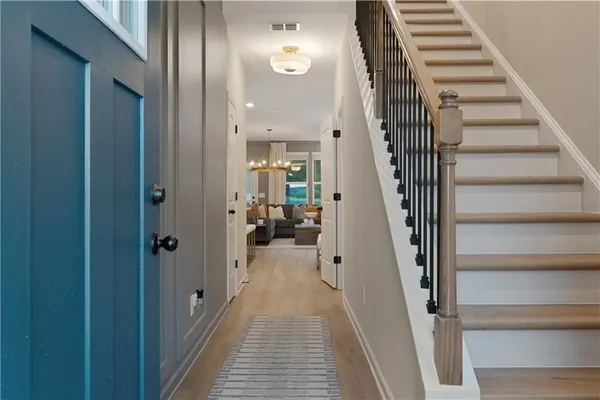 a view of a hallway with wooden floor and entryway