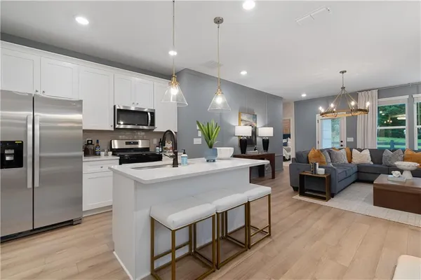 a large kitchen with kitchen island a large counter space stainless steel appliances and furniture